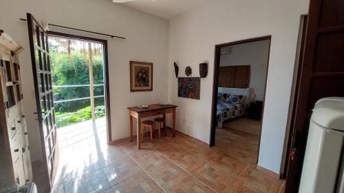a room with a table and a door to a bedroom at Villa Girassol in Ilhabela
