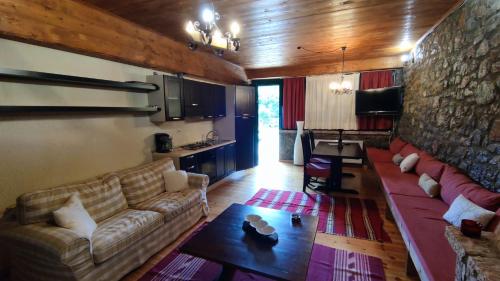 ein Wohnzimmer mit einem Sofa und einem Tisch in der Unterkunft Traditional cozy apartments in Livadi Parnassos in Kalívia