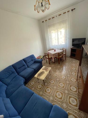 a living room with a blue couch and a table at da Lilia in Salute&Bellezza in Monfalcone
