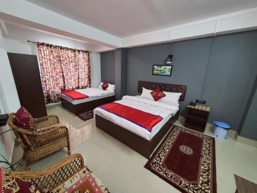 een slaapkamer met twee bedden en een stoel en een raam bij Chunnihome in Gangtok