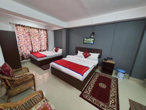 een slaapkamer met twee bedden en een stoel en een raam bij Chunnihome in Gangtok