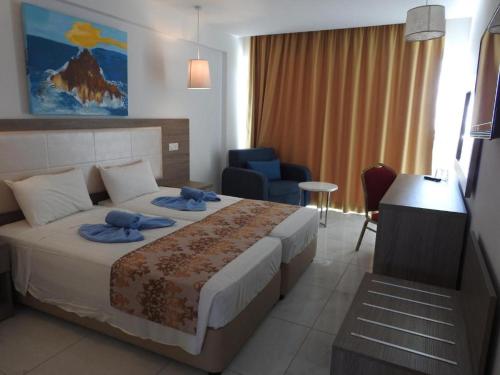 a hotel room with a bed with blue towels on it at Corfu Hotel in Ayia Napa