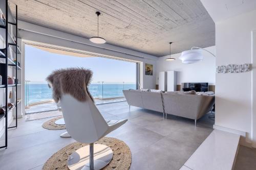 a living room with a large window and a surfboard at Superb Seafront Family Apartment in Sliema