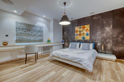 a bedroom with a bed and a table and a chair at Superb Seafront Family Apartment in Sliema
