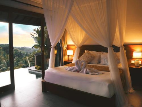 a bedroom with a canopy bed with a view at Abinawa Hill in Lovina