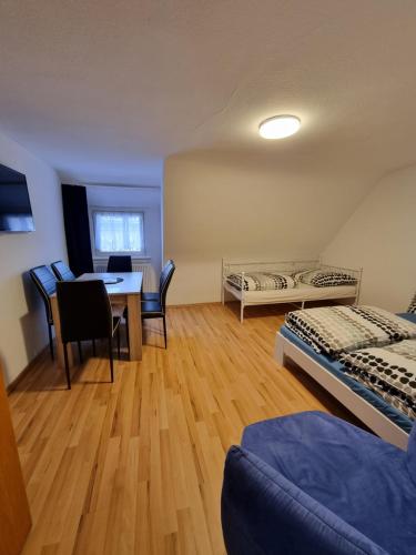 Cette chambre comprend deux lits, une table et des chaises. dans l'établissement KM3 Apartment, à Triberg
