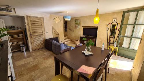 un salon avec une table à manger et un salon dans l'établissement Le jardinet de Rosa Maison de village, à Eygalières