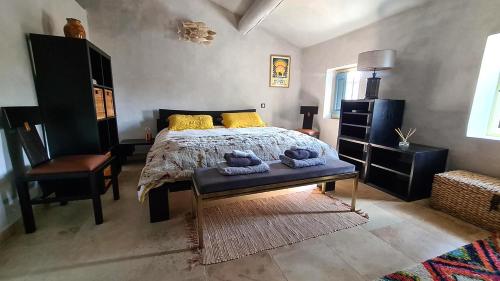 une chambre avec un lit, un bureau et une chaise dans l'établissement Le jardinet de Rosa Maison de village, à Eygalières