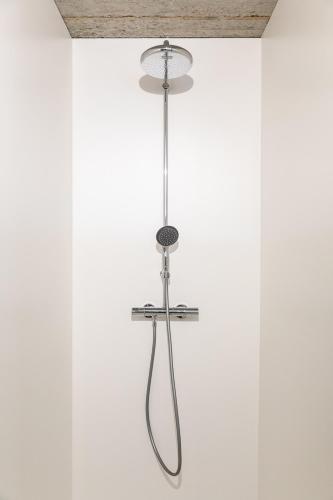 a shower in a white room with a ceiling at Le Garage in Theux