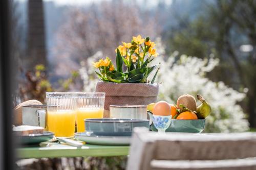 a table with a bowl of fruit and orange juice at Le Garage in Theux