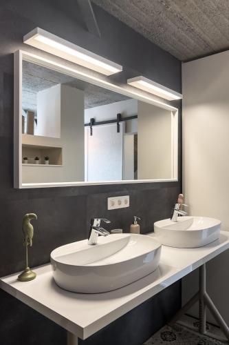 a bathroom with two sinks and a large mirror at Le Garage in Theux