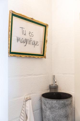 a sign on a wall above a sink in a bathroom at Le Garage in Theux