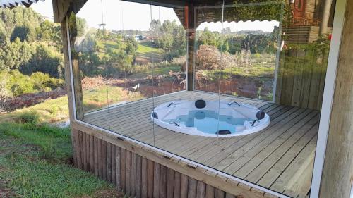 uma banheira de hidromassagem sentada num deque de madeira em CHALÉ ESTÂNCIA OURO VERDE em Lages