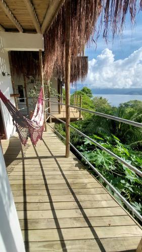 a hammock on a porch with a view of the ocean at Villa Girassol in Ilhabela