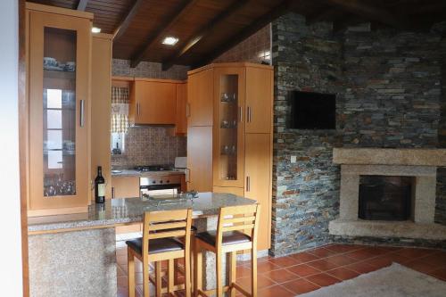 a kitchen with a table and chairs and a fireplace at Casa Da Formiga in Juncal de Cima