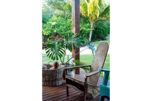 a porch with a chair and a table with plants at Orixás Residence in Morro de São Paulo