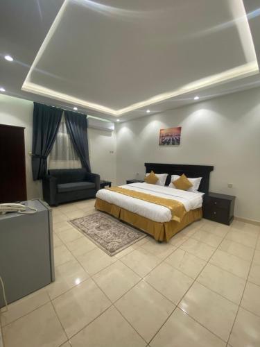 a large bedroom with a bed and a couch at أركانا للشقق المخدومة in Tabuk