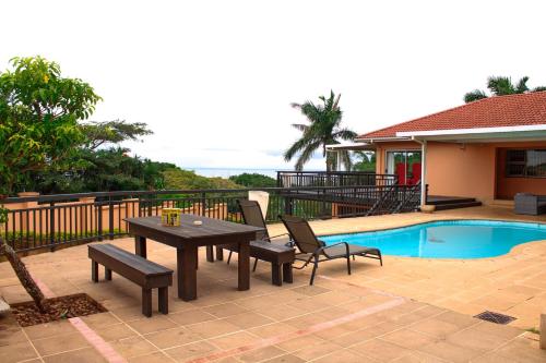 a patio with a table and chairs next to a pool at Seaview Executive Guest House in Mtunzini