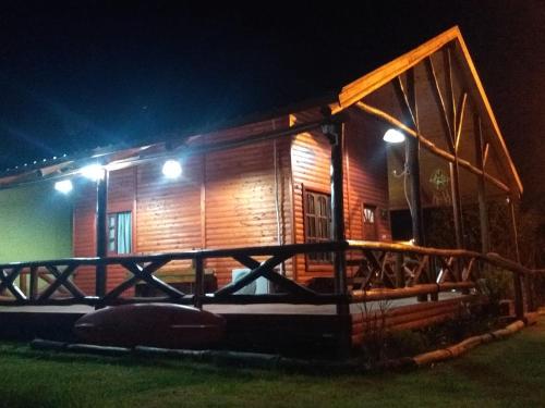 eine Holzhütte in der Nacht mit Beleuchtung in der Unterkunft Cabaña La Justina in San José