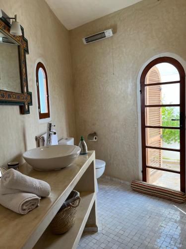 a bathroom with a sink and a toilet and a mirror at RIAD OASIS D'ASILAH in Asilah