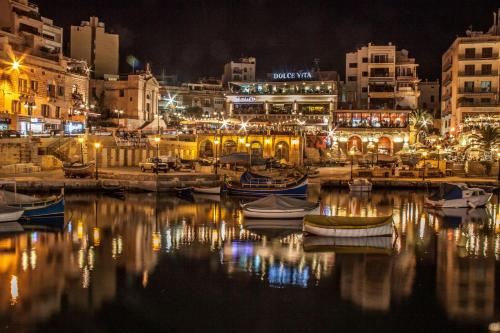 a harbor at night with boats in the water at Superb Seafront Family Apartment in Sliema