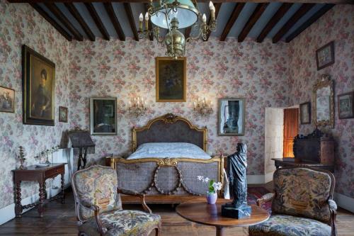 a bedroom with a bed and a table and chairs at Un Logis en Angoumois in Rancogne