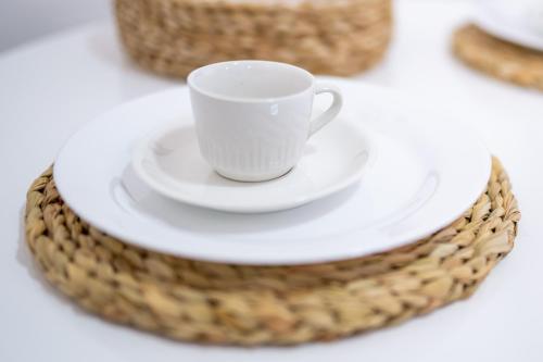 a white coffee cup on a plate on a table at Acoara Beco Doce in Jericoacoara