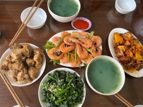 stół z talerzami jedzenia i miskami zupy w obiekcie Tamcoc Mr. Cau Homestay w mieście Ninh Binh
