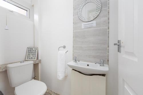 uma casa de banho branca com um WC e um lavatório em Avella Suites em Lytham St Annes