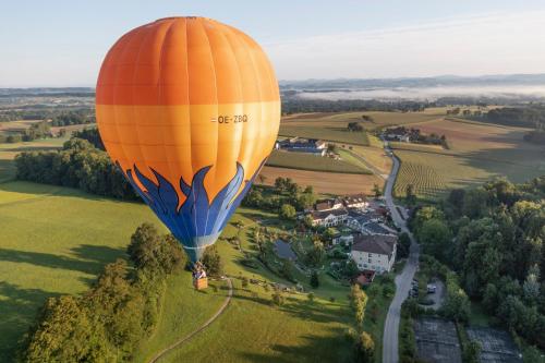 an orange and blue hot air balloon flying over a field at RelaxResort Kothmühle in Neuhofen an der Ybbs