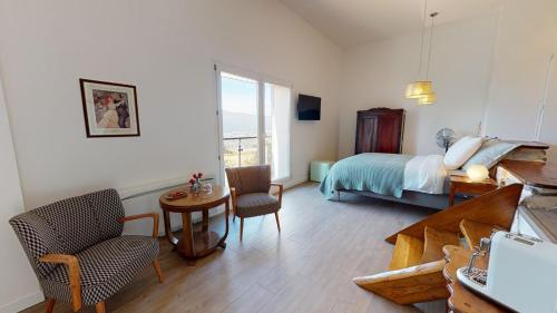 une chambre avec un lit, une table et des chaises dans l'établissement Le Paradis des Gen(t)s, à Seyssel