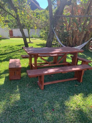 a picnic table with a hammock and a bench at Cabañas de Tzununa in Tzununá