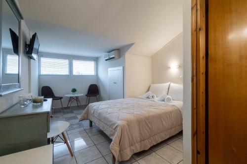 a bedroom with a bed and a table and chairs at Olympus View Rooms Sauna & Spa in Litochoro