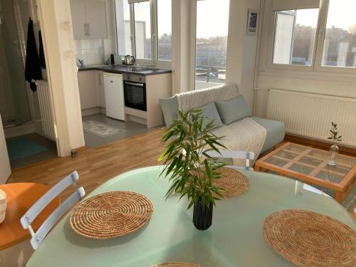 - un salon avec une table et une plante dans l'établissement Très bel appartement vue Mer - Les Ilots bleus - Dunkerque Malo les Bains, à Dunkerque