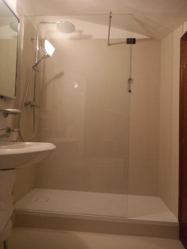 a glass shower in a bathroom with a sink at Hotel Valentino Centro Storico in Orvieto