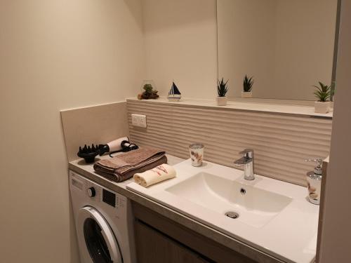 une salle de bain avec un lavabo et une machine à laver dans l'établissement Aux 4 bleutées, à Nice