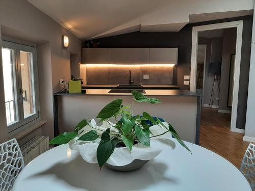 a kitchen with a white table with a plant on it at MoAA - Modern Art Apartment in Desenzano del Garda