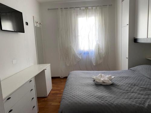 sypialnia z łóżkiem z komodą i oknem w obiekcie Appartamento Aurelia w mieście Molina di Ledro