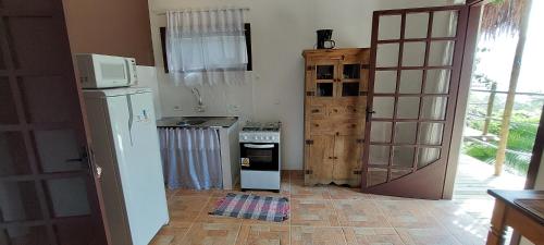 a kitchen with a refrigerator and a stove at Villa Girassol in Ilhabela
