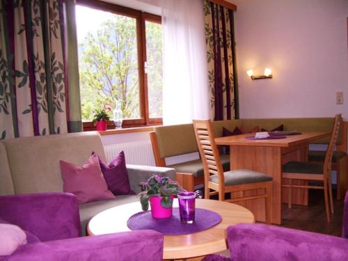 a living room with purple chairs and a table at Haus Alpina in Häselgehr