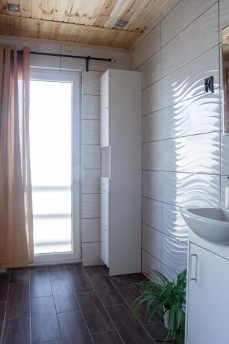a bathroom with a sink and a door with a window at OW Wilk - pokoje i domki z aneksami kuchennymi, parking, plac zabaw in Łeba