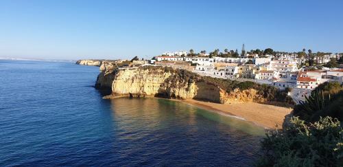 a view of a beach with white houses on a cliff at ML Carvoeiro Mar Apartment in Carvoeiro