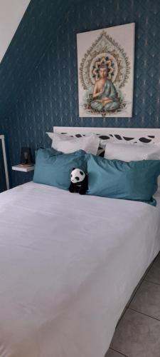 a bed with a panda bear sitting on top of it at Le Nid de l'Ecureuil in Selles-sur-Cher
