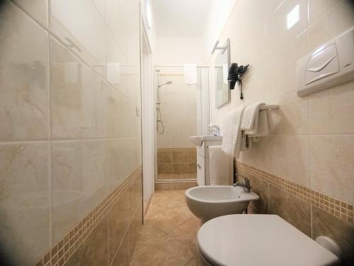 La salle de bains blanche est pourvue d'une douche et de toilettes. dans l'établissement B&B Casa Denittis, à Peschici
