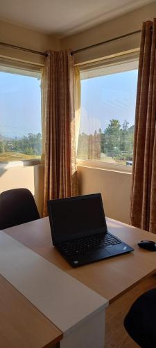 a laptop computer sitting on a table with a window at Salora Kodai in Kodaikānāl