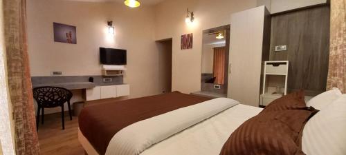 a hotel room with a bed and a desk at Salora Kodai in Kodaikānāl