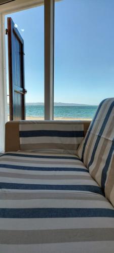 a bed in a room with a view of the ocean at Casa da Gino in Calasetta
