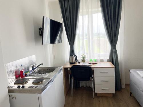 a small kitchen with a sink and a desk with a stove at Wohnen mit Bergausblick in Wals