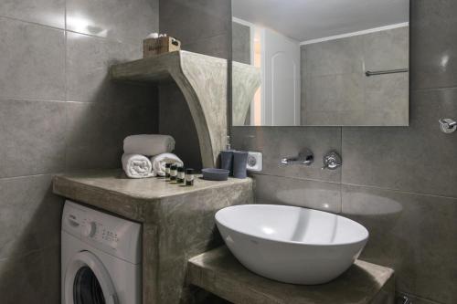 een badkamer met een wastafel en een wasmachine bij Emanouela's apartement in the center of Adamas in Adamas