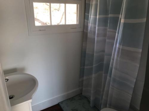 a bathroom with a sink and a window at Lakeshore Fishing Cabin #3, Ramp, dock, fire pit in Lake Ozark